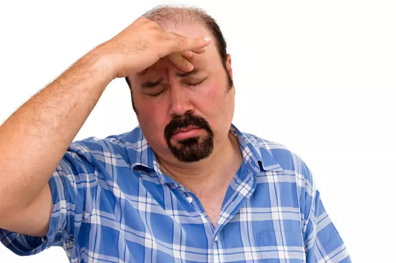 Overvektig mann som ser bekymra ut