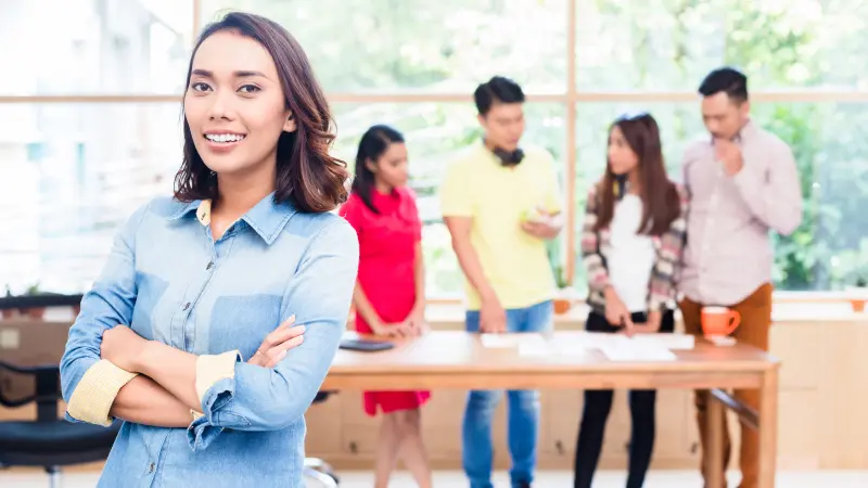 Ung asiatisk kvinne med selvtillit på jobb